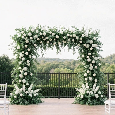 Large-scale floral arch for a wedding ceremony with lush greenery and white flowers