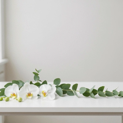 Minimalist wedding floral arrangement with a few elegant blooms and greenery, on a simple white table